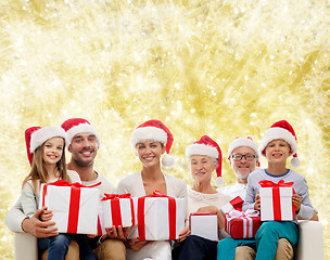 Image showing happy family in santa helper hats with gift boxes