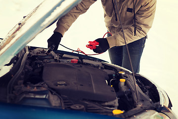 Image showing closeup of man under bonnet with starter cables