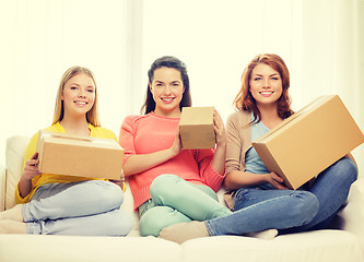 Image showing smiling teenage girls with cardboard boxes at home