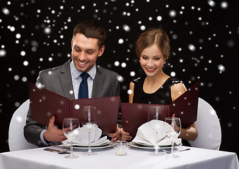 Image showing smiling couple with menus at restaurant