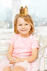 Image showing smiling little girl in crown sitting on sofa