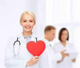 Image showing smiling female doctor with heart and stethoscope