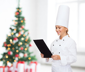 Image showing smiling female chef with black blank paper