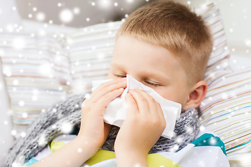Image showing ill boy blowing nose with tissue at home