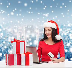 Image showing smiling woman with gifts, laptop and credit card
