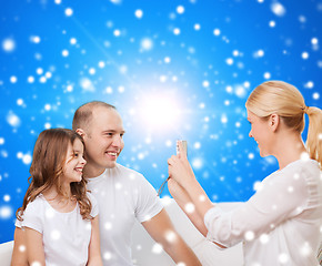 Image showing happy family with camera at home