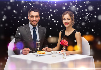 Image showing smiling couple eating dessert at restaurant