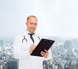 Image showing smiling male doctor with clipboard and stethoscope