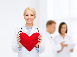 Image showing smiling female doctor with heart and stethoscope