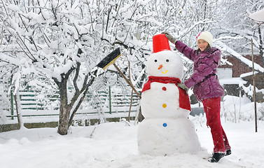 Image showing snowman and young girl