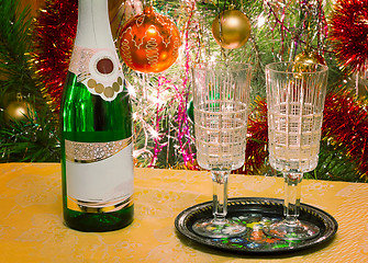 Image showing Christmas holiday, wine and glasses near a Christmas fir-tree.