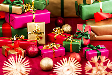 Image showing Numerous Xmas Gifts Arranged on a Red Cloth