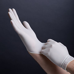 Image showing Putting on latex gloves