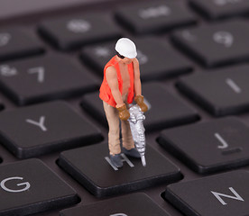 Image showing Miniature worker with drill working on keyboard