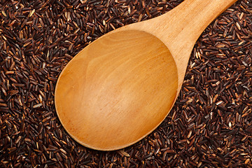 Image showing Wooden spoon on Thai Red Cargo rice