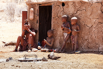 Image showing Himba woman with childs on the neck in the village