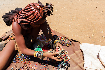 Image showing Himba girl with souvenirs for sale in traditional village