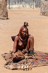 Image showing Himba girl with souvenirs for sale in traditional village