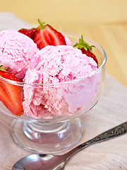 Image showing Ice cream strawberry in glass goblet on napkin