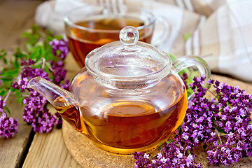 Image showing Tea of oregano in glass teapot on board with cup