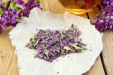 Image showing Oregano is dry on the paper with cup on board