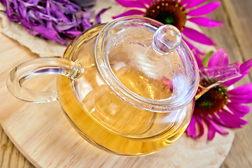 Image showing Tea from Echinacea in glass teapot on board