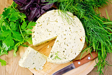 Image showing Cheese homemade round with greens on board