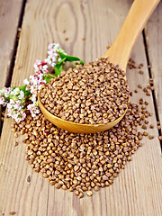 Image showing Buckwheat in wooden spoon with flower on board