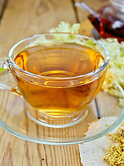 Image showing Tea from meadowsweet in cup and teapot on board