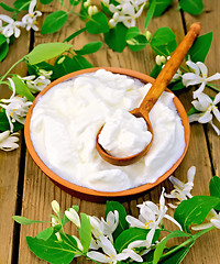 Image showing Yogurt in clay bowl with spoon and flowers of honeysuckle