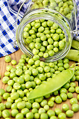 Image showing Green peas in glass jar on board