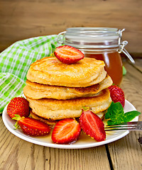 Image showing Flapjacks with strawberries and honey on board