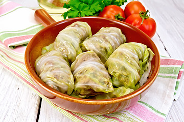 Image showing Cabbage stuffed and carrots in ceramic pan on board