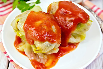 Image showing Cabbage stuffed and tomato sauce in plate on board