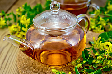 Image showing Tea from tutsan in glass teapot on board