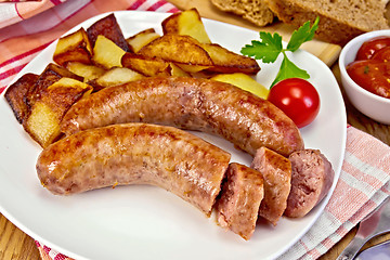 Image showing Sausages pork fried with potatoes in plate on board