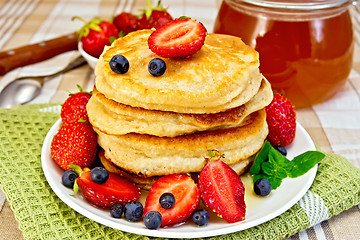 Image showing Flapjacks with strawberries and blueberries on napkin