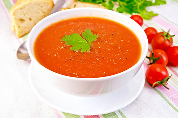 Image showing Soup tomato in bowl on linen napkin
