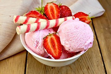 Image showing Ice cream strawberry in bowl with wafer rolls on board