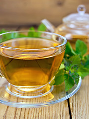 Image showing Tea with mint and teapot on wooden board