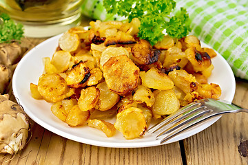 Image showing Jerusalem artichokes fried with parsley in bowl on board