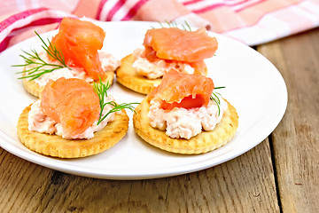 Image showing Crackers with cream and salmon on board