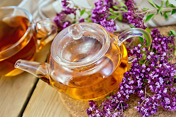 Image showing Tea of oregano in glass teapot on board