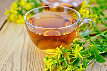 Image showing Tea from tutsan in glass cup on board