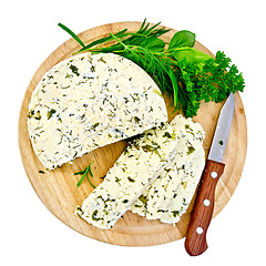 Image showing Cheese homemade with knife and herbs on round board