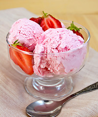 Image showing Ice cream strawberry in glass goblet on napkin and board