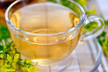 Image showing Tea from tutsan in glass cup on tablecloth