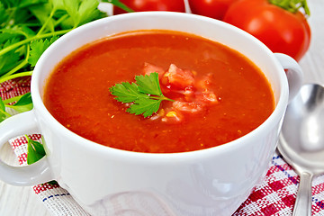 Image showing Soup tomato with spoon on napkin and board