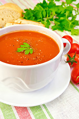 Image showing Soup tomato in bowl with tomatoes on linen napkin