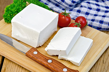 Image showing Feta with tomato and knife on wooden board